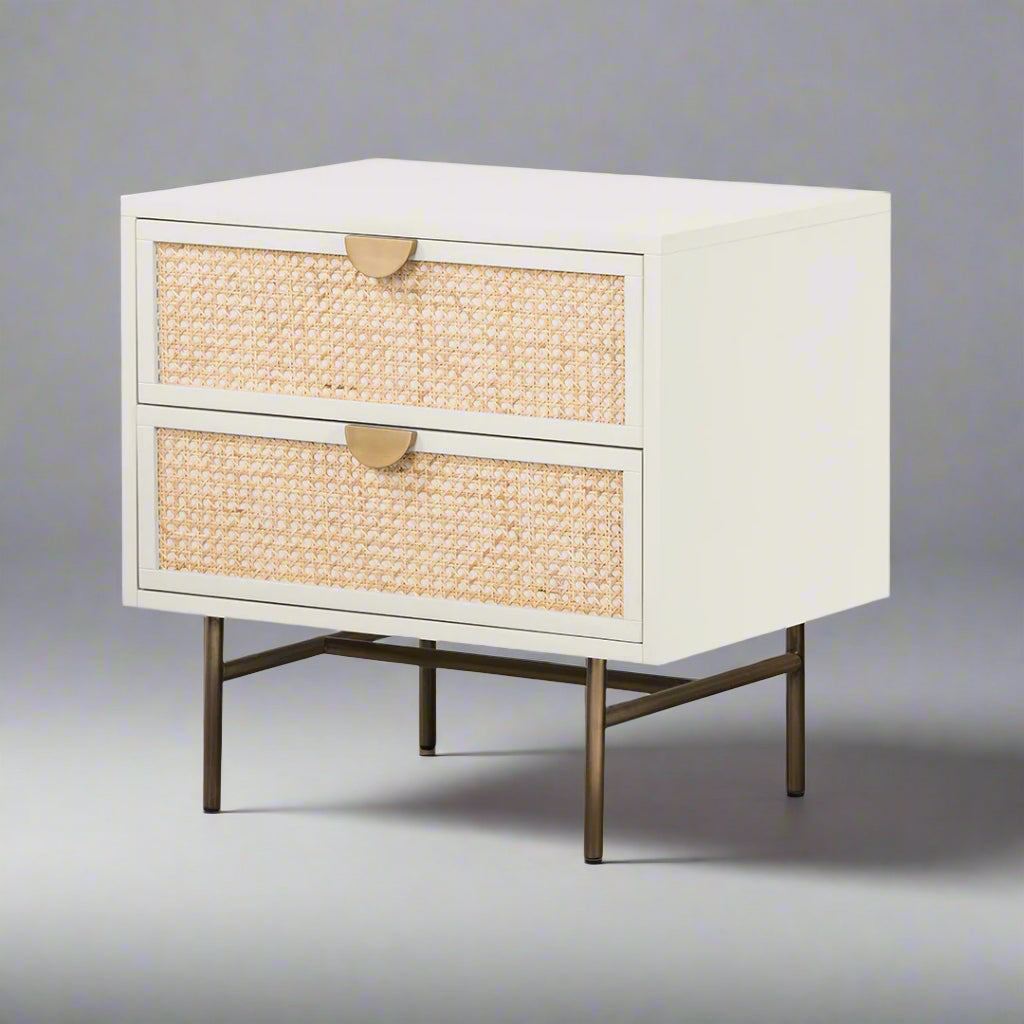 White nightstand with woven drawers and gold handles on a white background